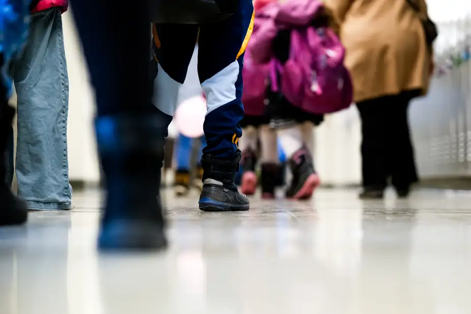Des personnes marchent dans le corridor d’une école