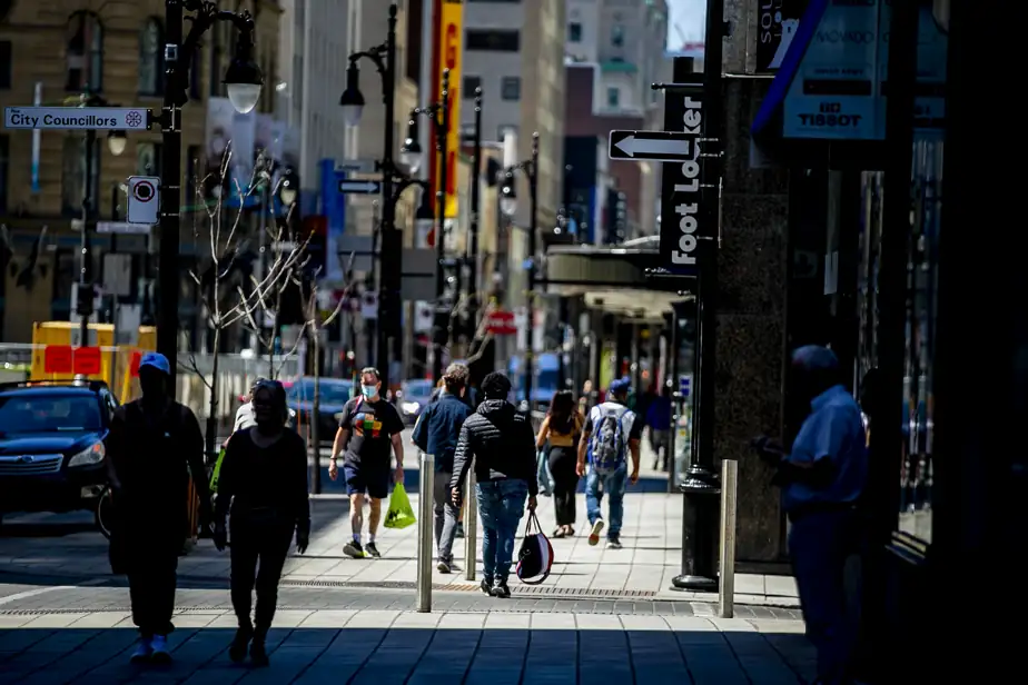 Des piétons marchent sur une rue commerciale à Montréal.